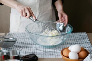Zubereitung eines Käsekuchen mit Schneebesen