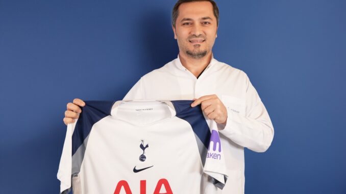 Bild zeigt, wie Dr. Abdulaziz Balwi ein Trikot des Premiere League Klubs Tottenham Hotspur in beiden Händen hält