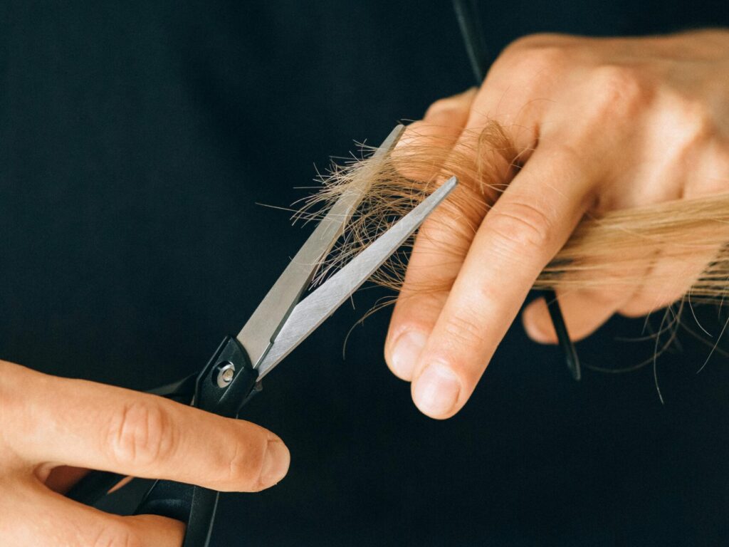 Haare zwischen Zeigefinger und Mittelfinger halten und schneiden